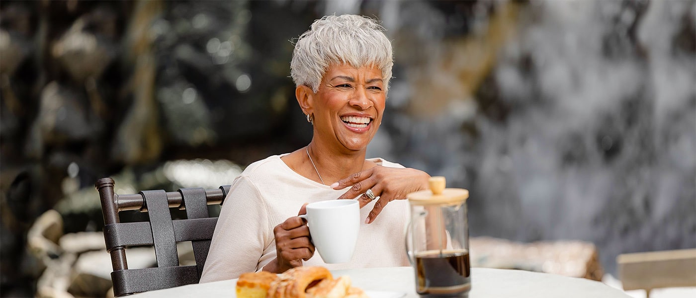lacosta-2024-1400x600-20 (2) a woman enjoying coffee outside